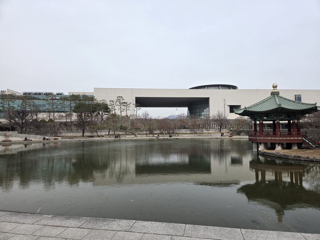 National Museum of Korea viewed across a pond with a traditional Korean pavilion